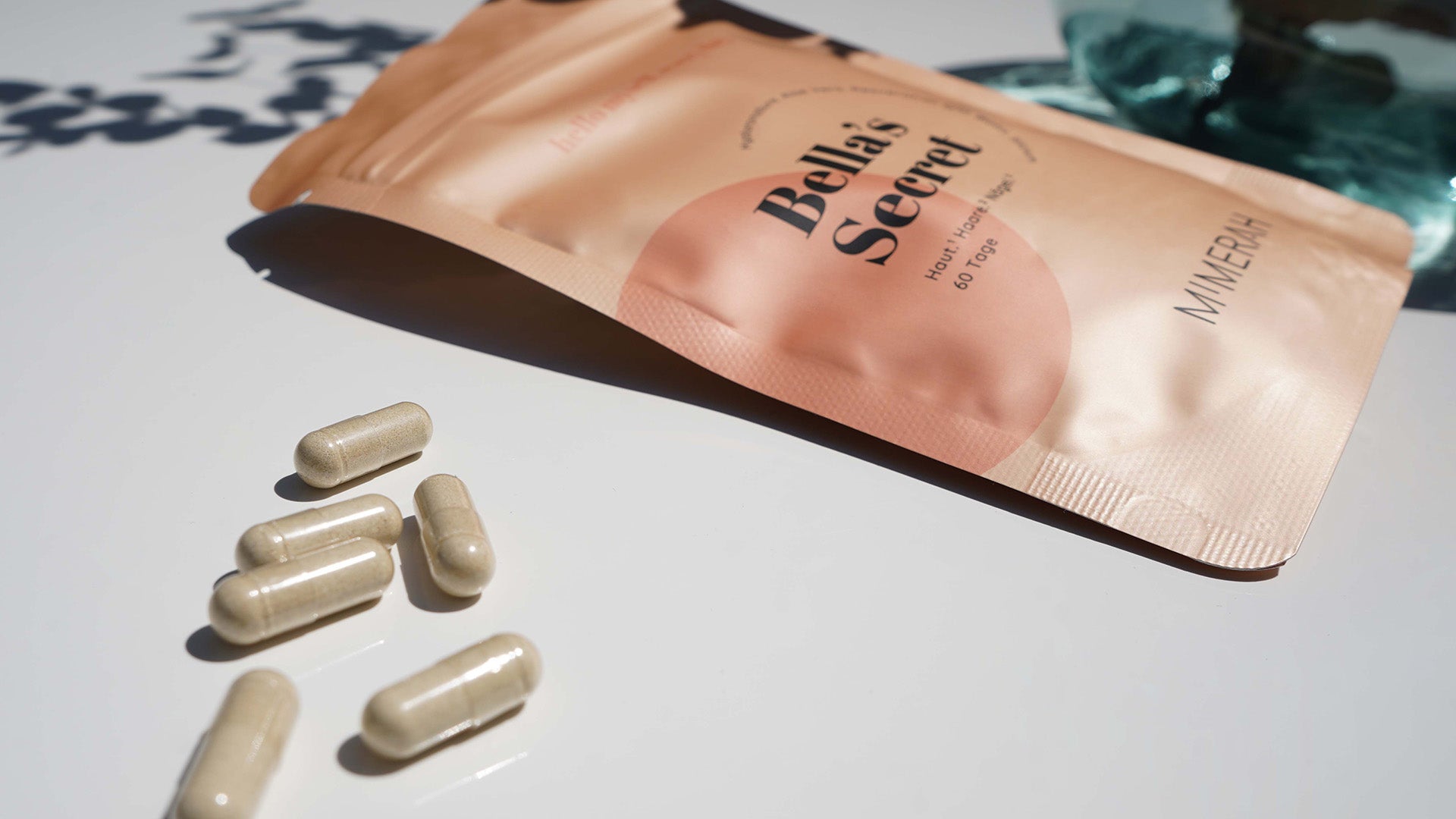 mimerah nahrungsergänzungsmittel für frauen Packung liegt auf einer weißen fläche daneben liegen die kapseln